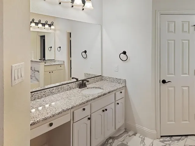 a bathroom with a granite countertop sink and a mirror