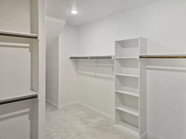 a view of walk in closet with empty racks