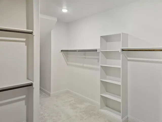 a view of walk in closet with empty racks