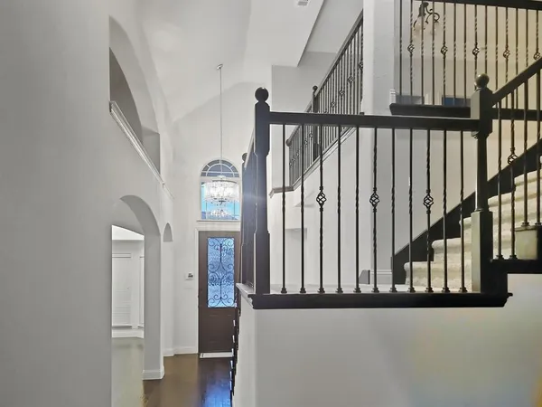 a view of staircase with railing and a window
