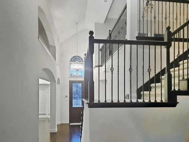a view of staircase with railing and a window