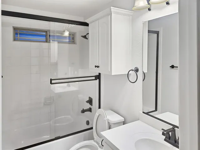 a bathroom with a shower a toilet and a sink
