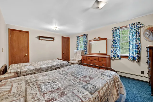 a bedroom with a bed and dresser with mirror