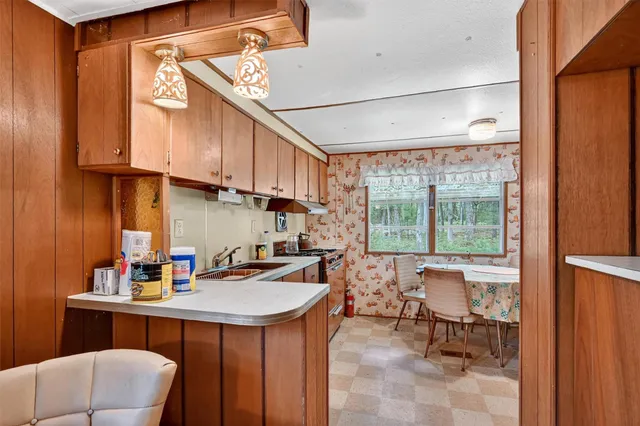 a kitchen with stainless steel appliances a sink a table and chairs in it