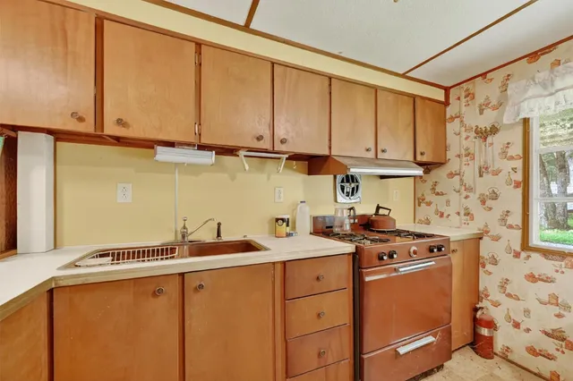 a kitchen with stainless steel appliances a sink stove and cabinets