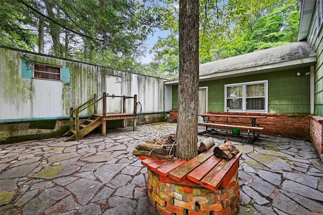 a backyard of a house with barbeque oven table and chairs