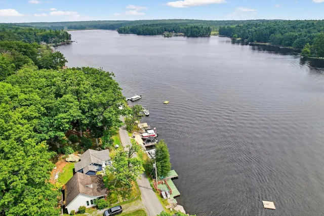 an aerial view of a house with a yard and lake view
