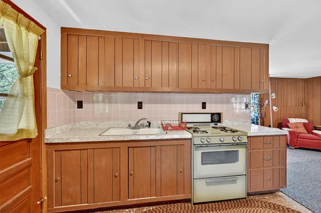 a kitchen with a stove sink and cabinets