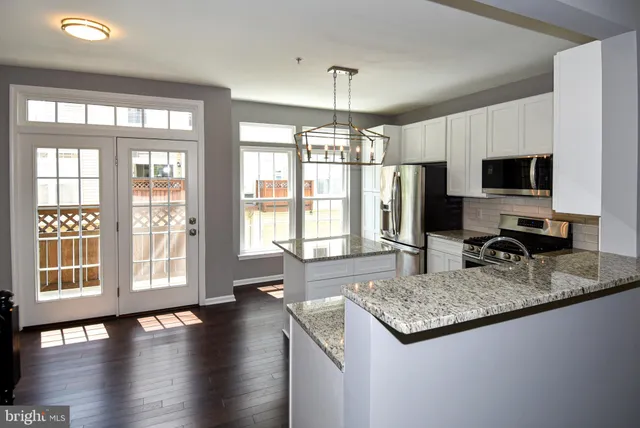 a kitchen with a counter top a stove cabinets a sink and a granite counter top