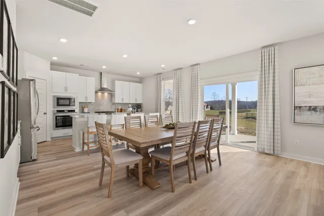 a view of a dining room with furniture a rug and wooden floor