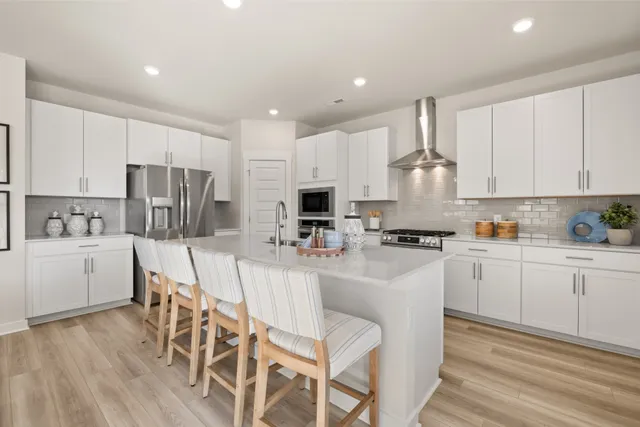 a kitchen with stainless steel appliances granite countertop a white cabinets and wooden floor
