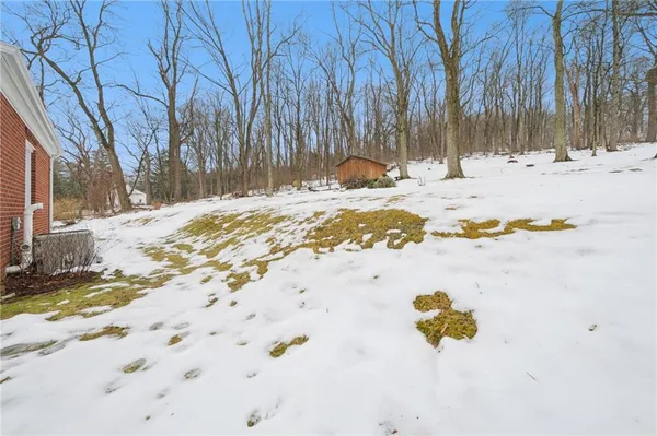 a view of the ocean with snow on the road