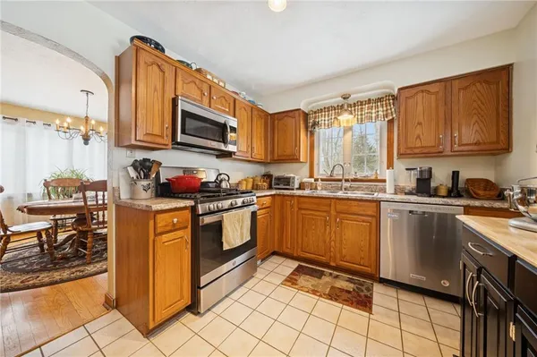 a kitchen with stainless steel appliances granite countertop a stove top oven a sink dishwasher and cabinets with wooden floor