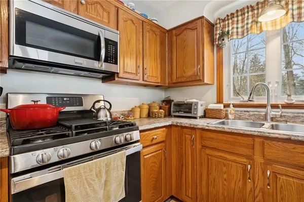 a kitchen with stainless steel appliances granite countertop a sink a stove microwave and cabinets