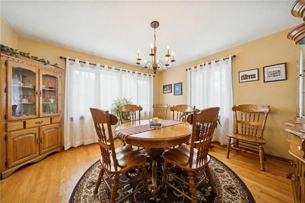 a dining room with furniture a chandelier and wooden floor