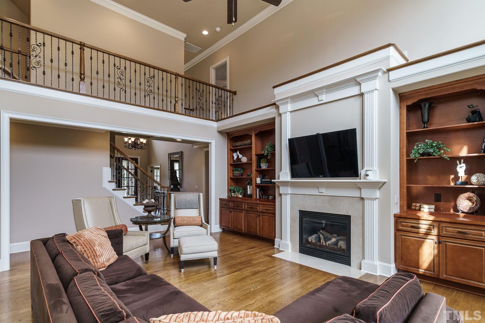 8313 Rue Cassini Court Raleigh, NC 27615 - Photo 13 of 74 a living room with furniture a flat screen tv and a fireplace