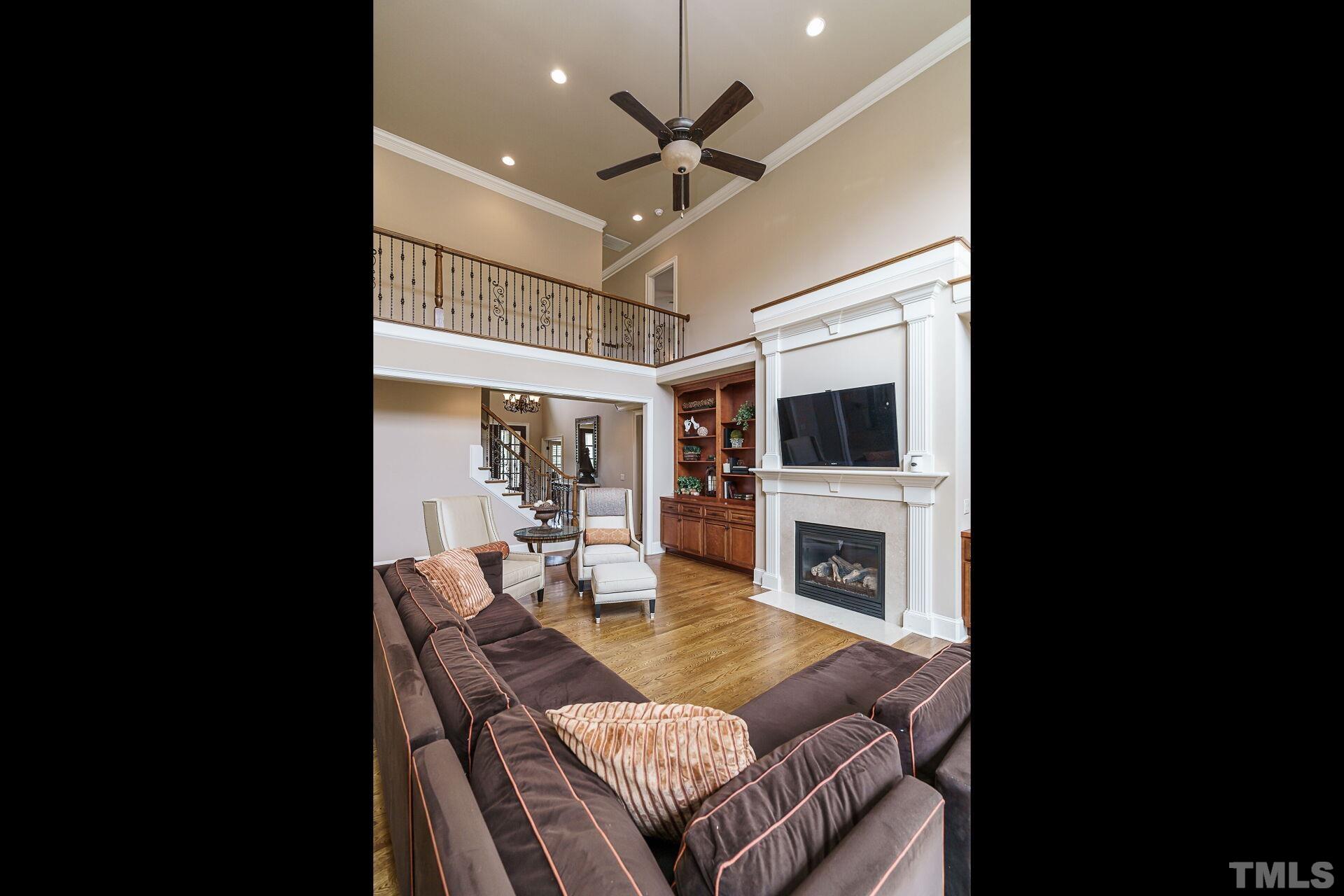8313 Rue Cassini Court Raleigh, NC 27615 - Photo 14 of 74 a living room with furniture a fireplace and a flat screen tv