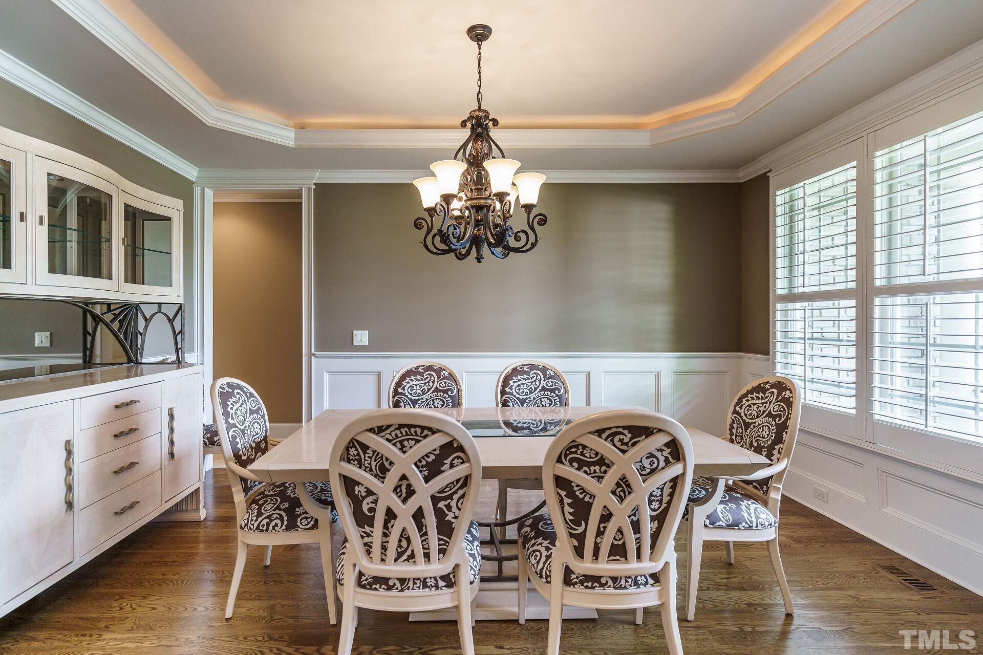 8313 Rue Cassini Court Raleigh, NC 27615 - Photo 16 of 74 a view of a dining room with furniture wooden floor and chandelier