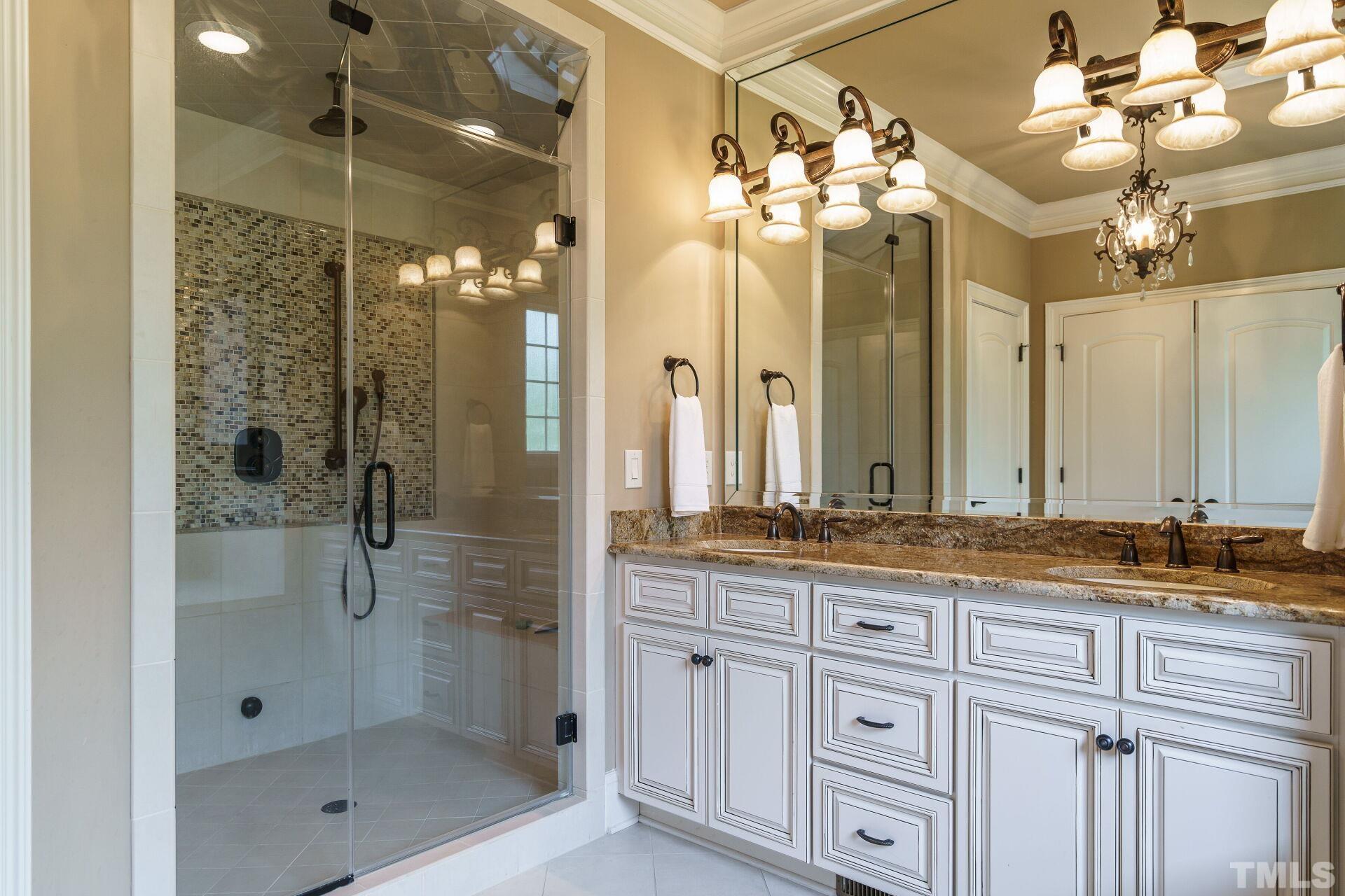8313 Rue Cassini Court Raleigh, NC 27615 - Photo 24 of 74 a bathroom with a double vanity sink mirror and shower