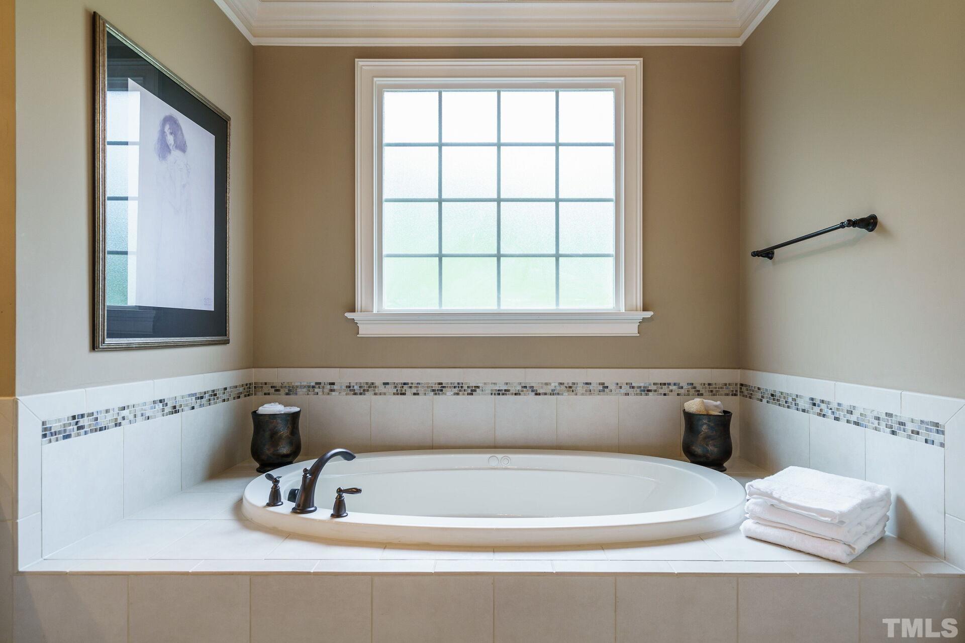 8313 Rue Cassini Court Raleigh, NC 27615 - Photo 25 of 74 a bathroom with a bathtub and a window