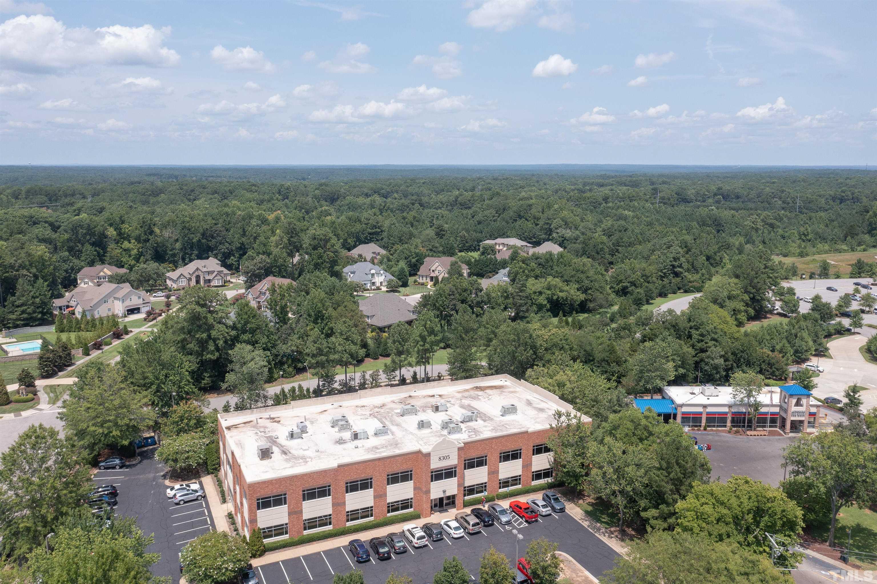 8313 Rue Cassini Court Raleigh, NC 27615 - Photo 60 of 74 an aerial view of a house with a yard and lake view