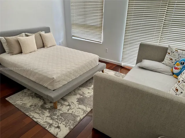 a bed sitting in a bedroom next to a window with lamp