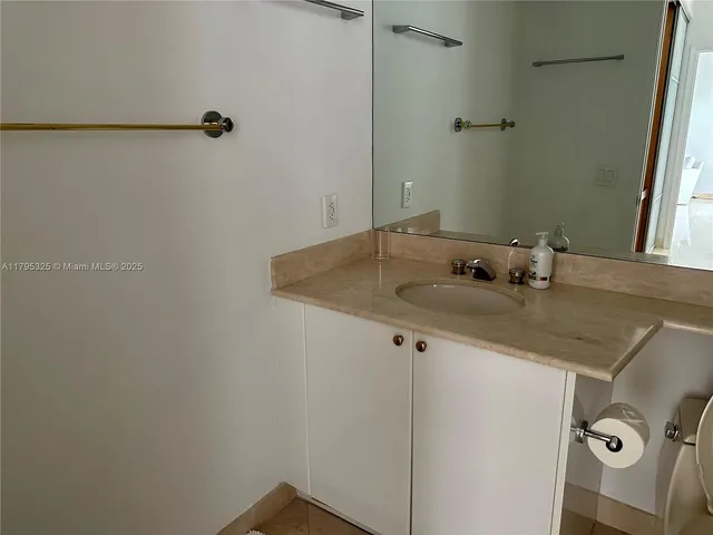 a bathroom with a granite countertop sink and white vanity