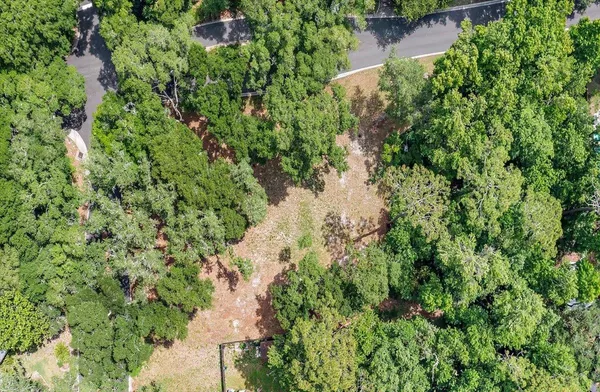 an aerial view of residential house with outdoor space and trees all around