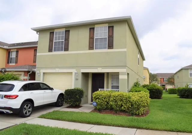 a white house covered with tall trees