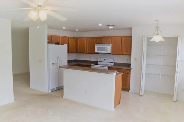a kitchen with stainless steel appliances granite countertop a refrigerator and a stove top oven