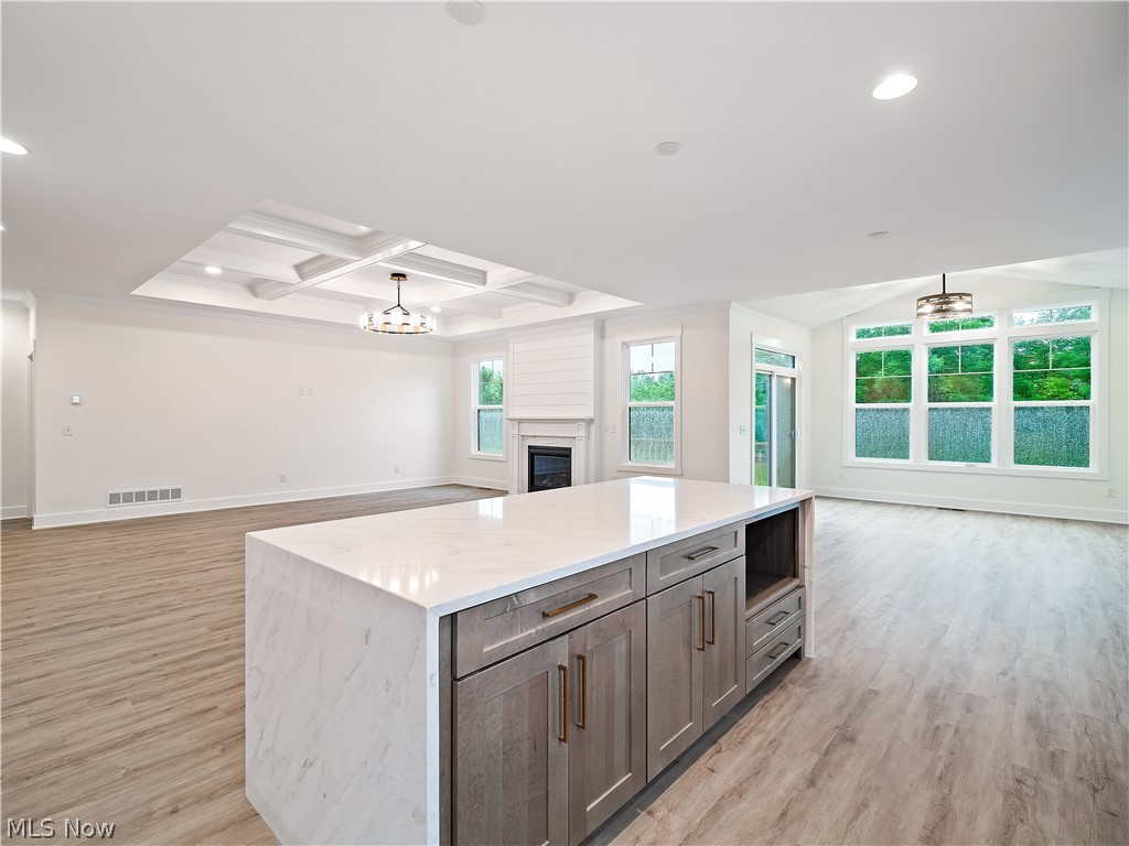 32 Brookside Lane North Ridgeville, OH 44039 - Photo 49 of 50 Kitchen featuring open floor plan, coffered ceiling, beam ceiling, recessed lighting, and a glass covered fireplace