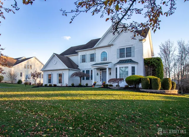 a view of a house with a big yard and large trees