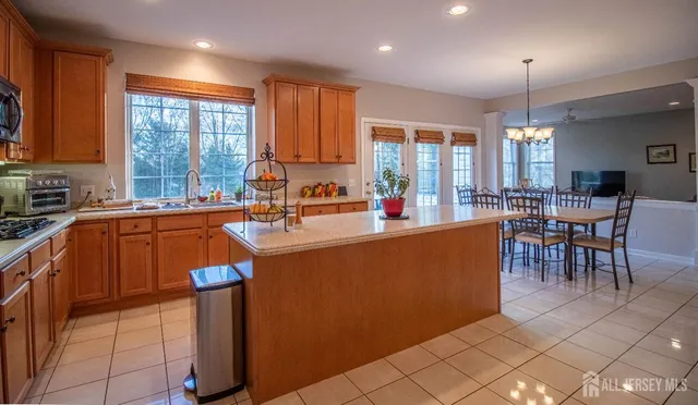 a kitchen with sink a refrigerator and chairs