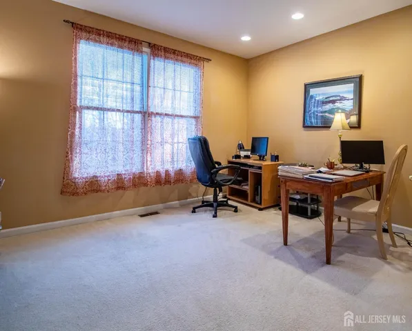 a view of a workspace with furniture and a window
