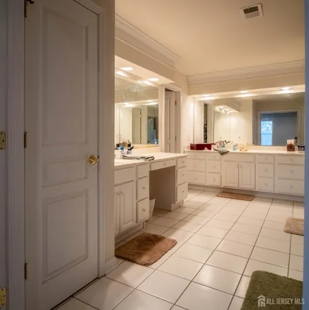 a large white kitchen with a sink and cabinets