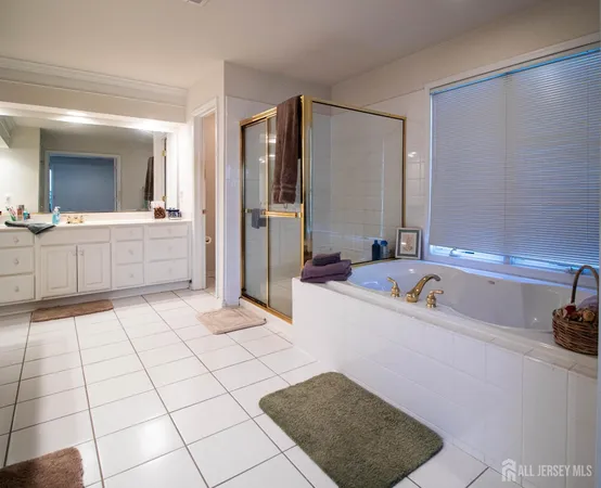 a large bathroom with a tub a sink and a large mirror