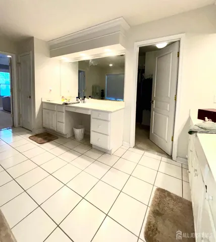 a large bathroom with a large mirror vanity and toilet
