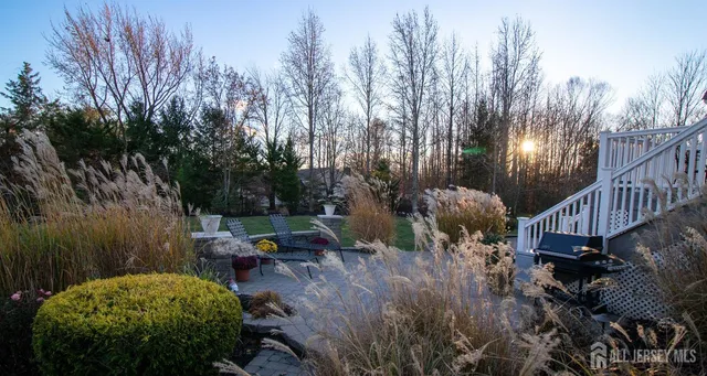 a backyard of a house with table and chairs plants