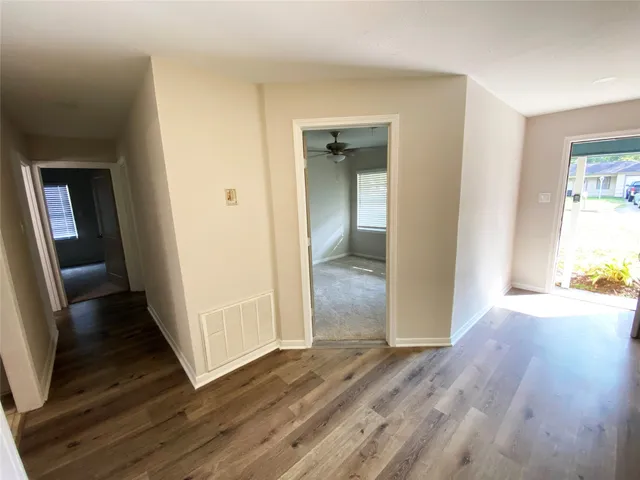 a view of a hallway with wooden floor and closet