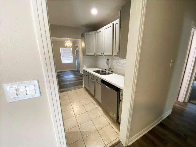 a kitchen with kitchen island granite countertop a sink and a refrigerator