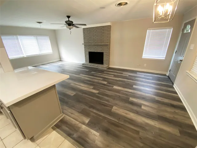 a view of an empty room with a fireplace and a window