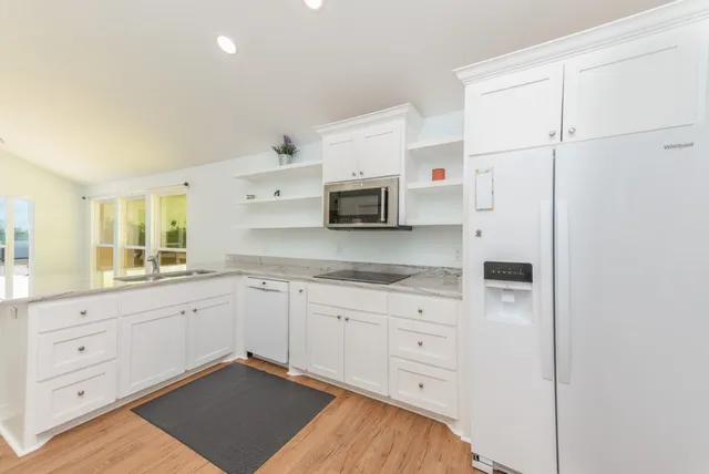 a bathroom with a granite countertop toilet sink and mirror