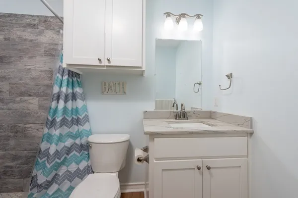a bathroom with a granite countertop sink toilet and a mirror
