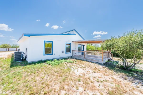 a view of kitchen and empty room with wooden floor