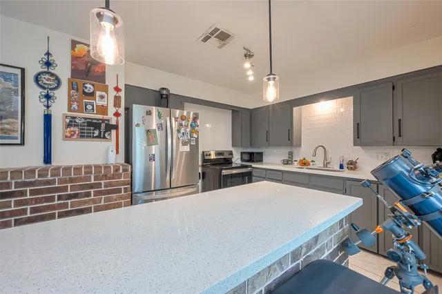 a large white kitchen with refrigerator stove and a sink