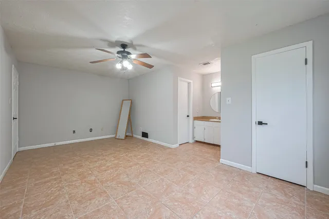a view of an empty room with a ceiling fan