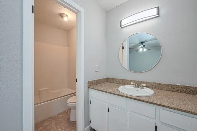 a bathroom with a toilet a sink and mirror