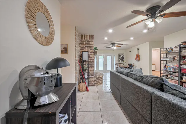 a living room with furniture a chandelier a mirror and a flat screen tv