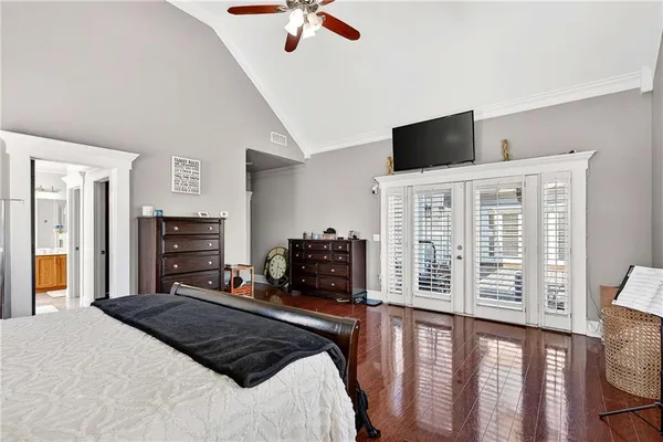 a bedroom with a bed a television and a large window