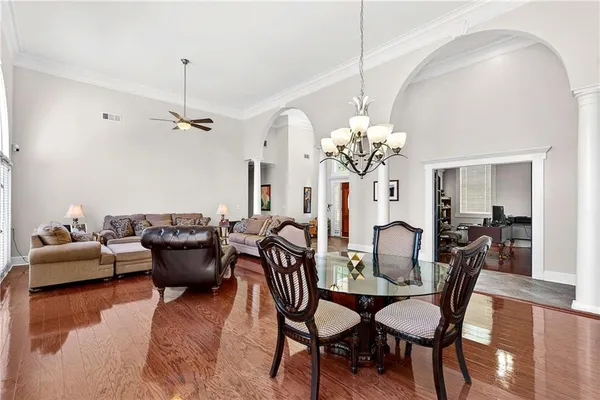a dining room with furniture a chandelier and wooden floor